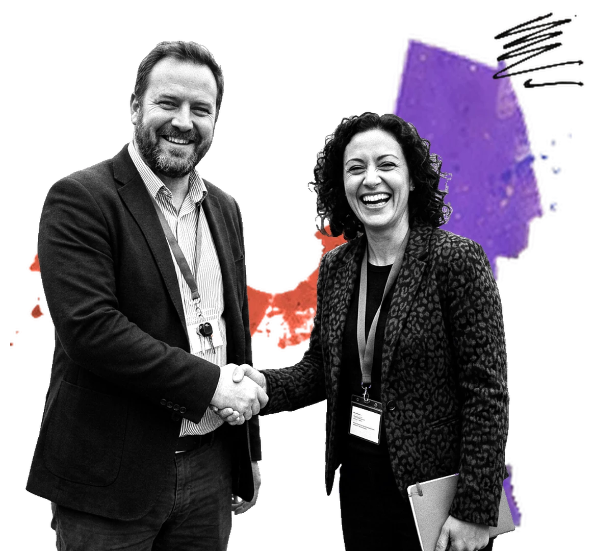 Two partners shake hands over purple and red paint