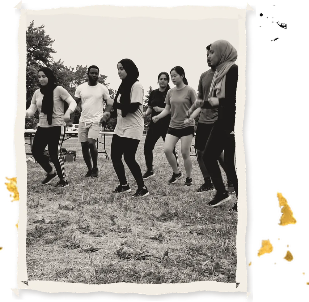 A group rehearsing a dance on the grass