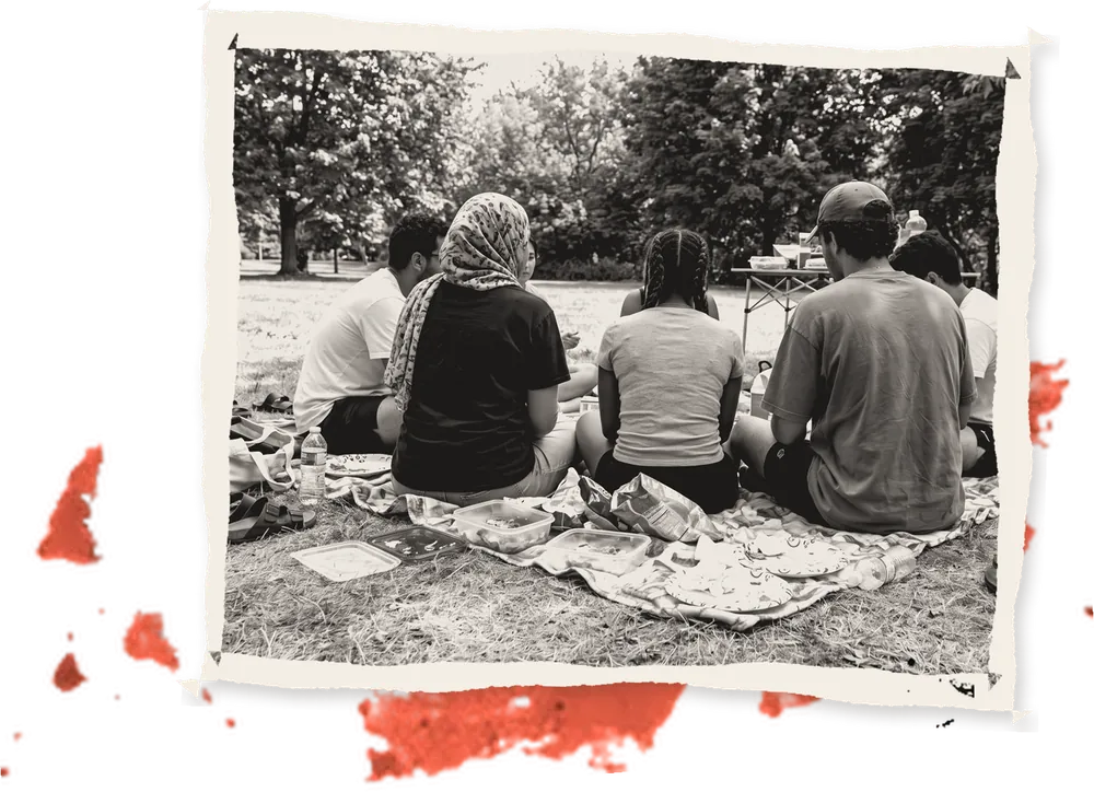Friends sitting on a blanket on the grass